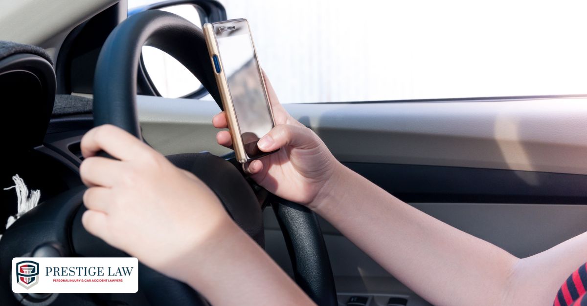 Driver looking at phone while driving, illustrating distracted driving behavior.
